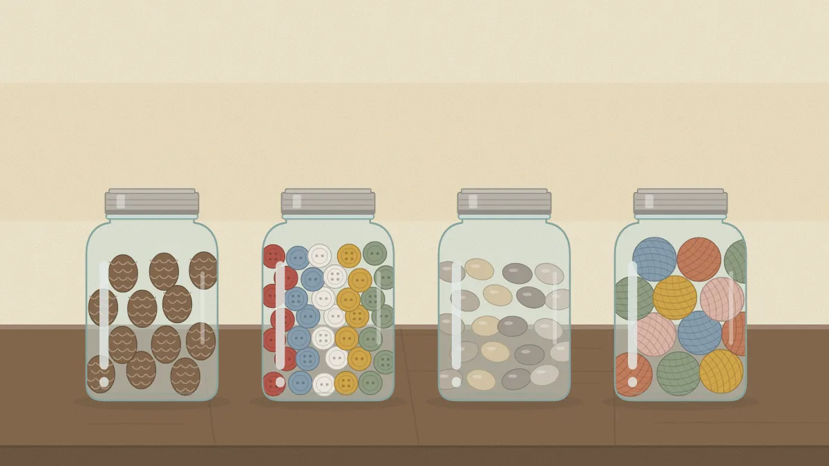 Four clear jars in a row filled with pinecones, buttons, smooth stones and small yarn balls
